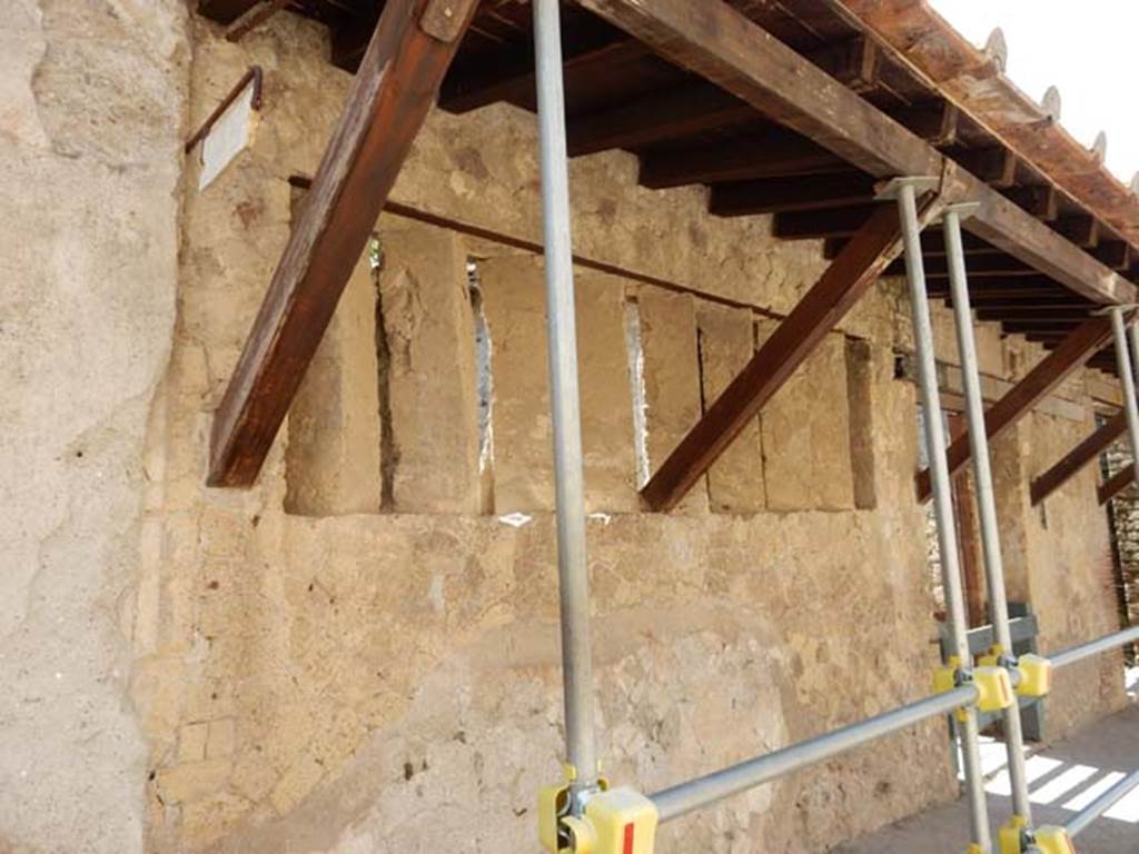 V.4 Herculaneum. May 2018. Looking  south along north end of façade, with marble plaque in position on boundary.
Photo courtesy of Buzz Ferebee.